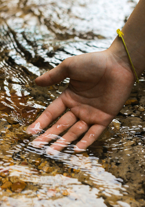 a calming picture with someone's hand dipping in the water