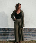 Woman with brown hair wearing the long sleeve plisse top opened with the matching olive plisse pants.