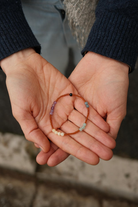 Calm Bracelet with colorful beads presented on someone's hands.