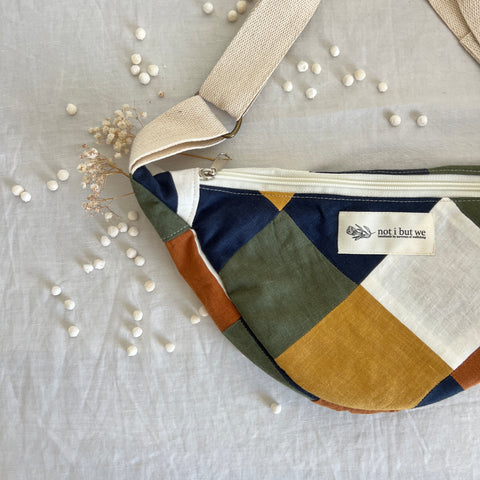 Unique Moonbag with white zipper, and blue, reen, white, and mustard patches.
