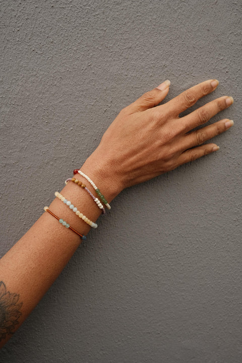 Not I But We's Mindful bracelets worn by a woman with a tattoo.