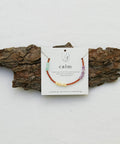 calm bracelet with beads presented on a piece of wood