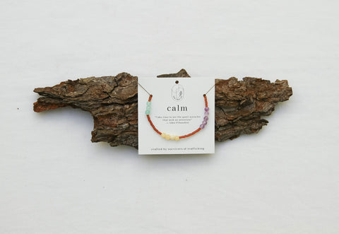 calm bracelet with beads presented on a piece of wood